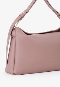 Grande borsa in pelle rosa con finitura texture, dotata di un'ampia apertura e di una sola tracolla con dettagli in oro decorativi.