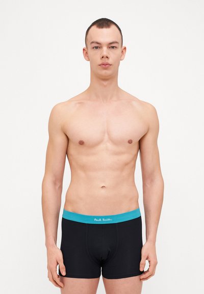 Boxer di colore nero con una fascia turchese che presenta il testo "Paul Smith". Tessuto liscio, design aderente, con un taglio classico.