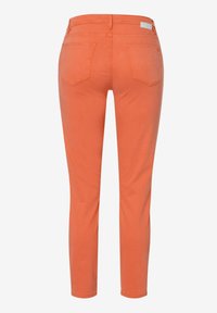 Pomarańczowe dżinsy w slim fit, z średnim stanem, pięcioma kieszeniami i subtelnymi przeszyciami na plecach.