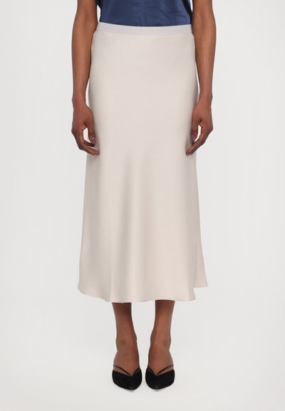 Midi skirt in light beige fabric, featuring a smooth texture and subtle drape, with a high waistband and side slit for ease of movement.