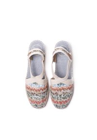 Zapatos de lona tejidos con un patrón multicolor en zigzag en la puntera y una parte superior de tela gris clara. Cuenta con una correa para un ajuste seguro.