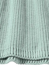 Gebreide deken in licht mintgroen. Bevat een gestructureerd patroon met verticale ribbels en een zachte, gezellige afwerking. De randen zijn keurig afgewerkt.