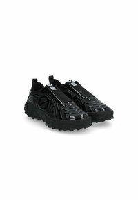 Le scarpe nere slip-on presentano un esterno in gomma lucida, un design testurizzato con motivi in rilievo e una suola imbottita con piccole protuberanze per una maggiore aderenza.