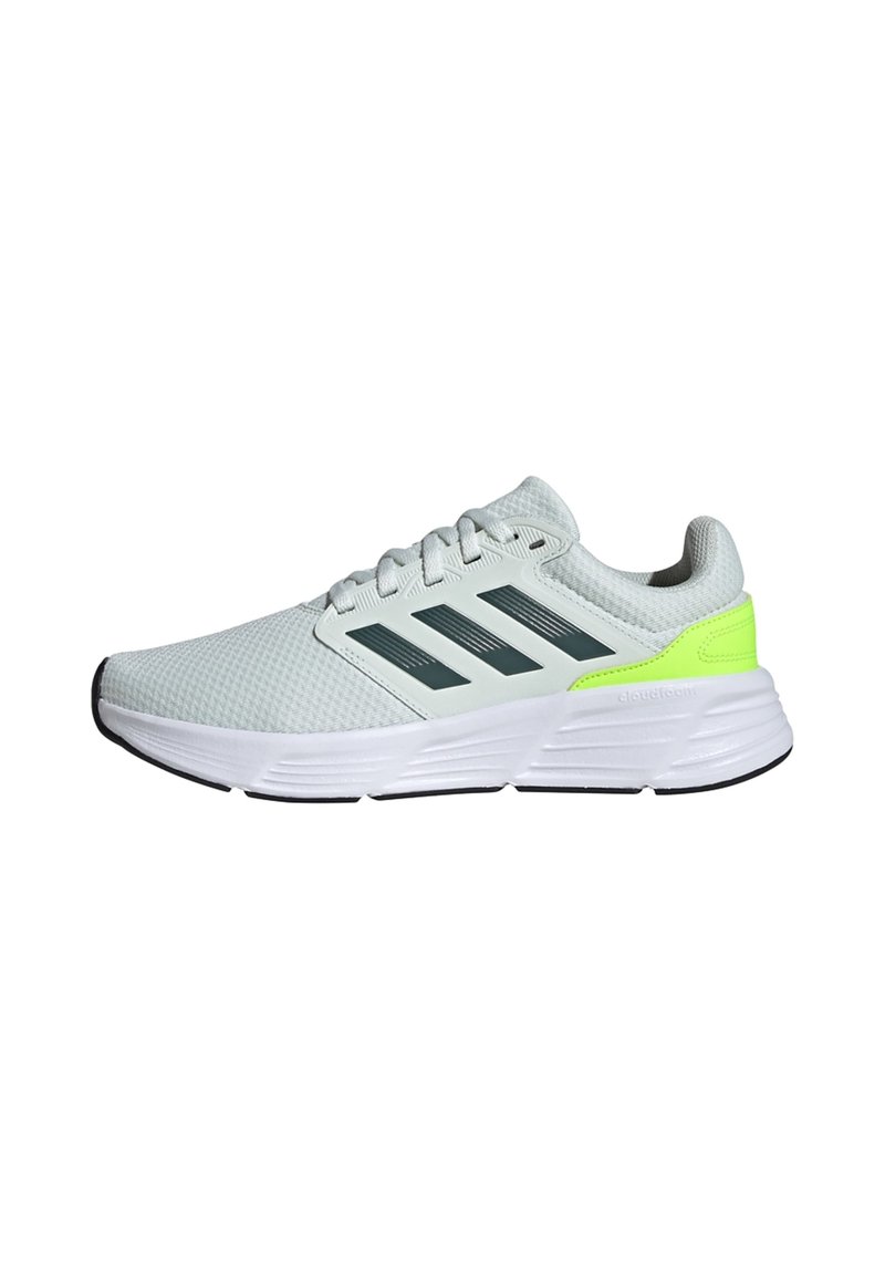 Baskets de sport gris clair avec une tige en maille texturée, présentant trois rayures gris foncé, un accent de talon vert fluo et une semelle blanche.