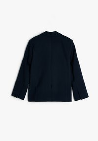 Blazer navy avec une silhouette ajustée, des revers crantés, des manches longues et une fente au dos. Fabriqué à partir d'un tissu texturé avec des détails de couture minimalistes.