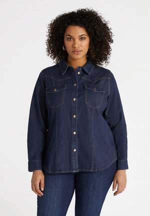 Dunkelblauses Denim-Hemd mit Kragen, Knopfleiste und zwei Brusttaschen. Hat hellbraune Nähte und lange Ärmel.