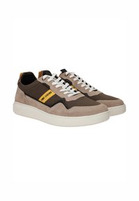 Sneakers met een mix van nubuck en stof in beige en bruin, voorzien van een witte rubberen zool, witte veters en een gele logo-accent.