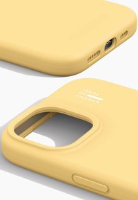 Funda de teléfono de silicona amarilla con cortes precisos para botones y cámara, con una textura mate y un logo impreso en blanco.