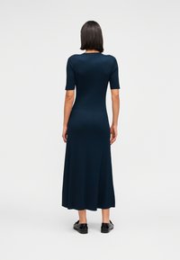 Φόρεμα από ριμπ πλεκτό ύφασμα σε ναυτικό μπλε, με κοντά μανίκια και φουσκωτή φούστα, διαθέτει στρογγυλή λαιμόκοψη και εφαρμοστό μπούστο. Μινιμαλιστικός σχεδιασμός.