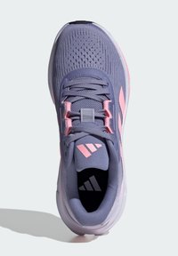 Chaussure de sport violette avec des accents roses, tige en tricot texturé, semelle flexible et logo à trois bandes proéminent sur la languette et le côté.