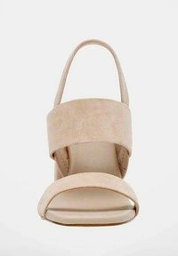 Sandal con tacco in suede beige, caratterizzata da una punta aperta, una larga cinturino alla caviglia e una texture liscia. Design minimalista con suola sagomata.