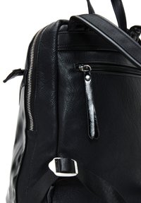 Sac à dos en cuir noir avec une finition texturée, plusieurs compartiments zippés et des bretelles réglables avec un détail en boucle argentée.