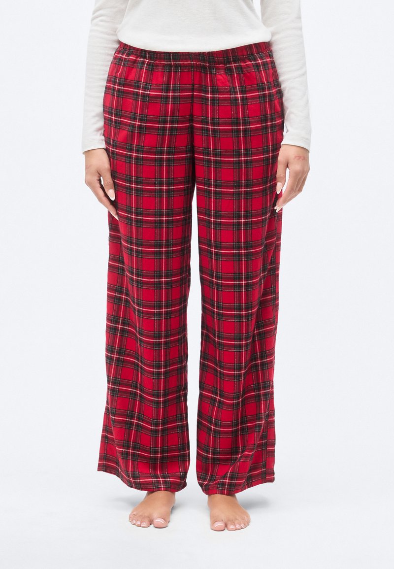 Κόκκινες πιτζάμες με καρό σχέδιο, φαρδύ μπατζάκι, ελαστική μέση και αντίθετες μαύρες γραμμές σε μοτίβο καρό.