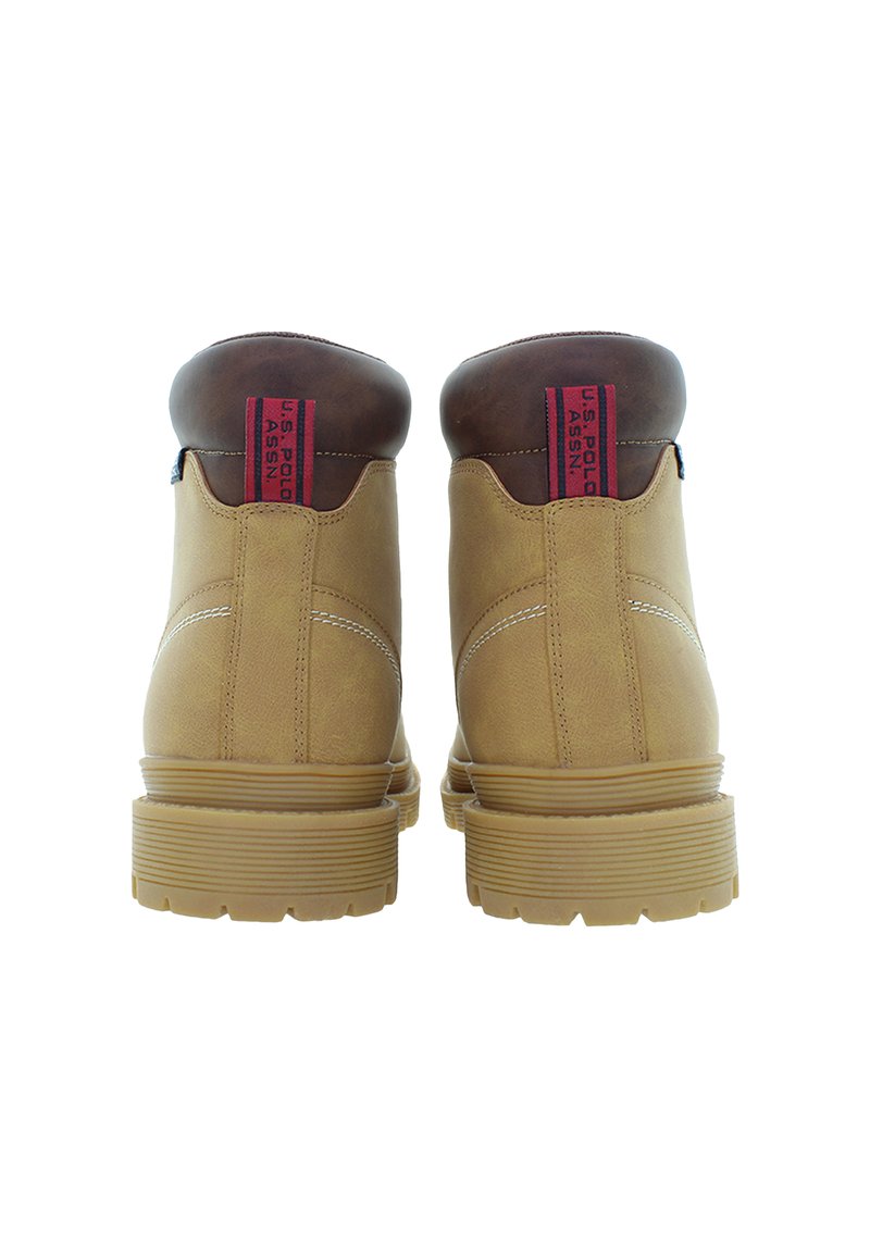 Bottines beiges et brunes à chevilles avec des semelles en caoutchouc épaisses, des coutures visibles et des tirettes rouges étiquetées "U.S. Polo Assn." vues de dos.