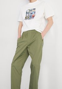 New Balance Tygbyxor - olive