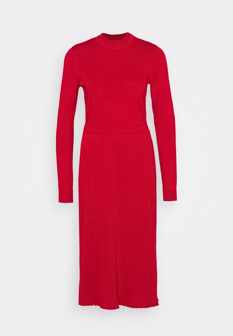 Robe tricotée rouge à manches longues, texture côtelée, col haut et corsage ajusté se transformant en une base évasée.