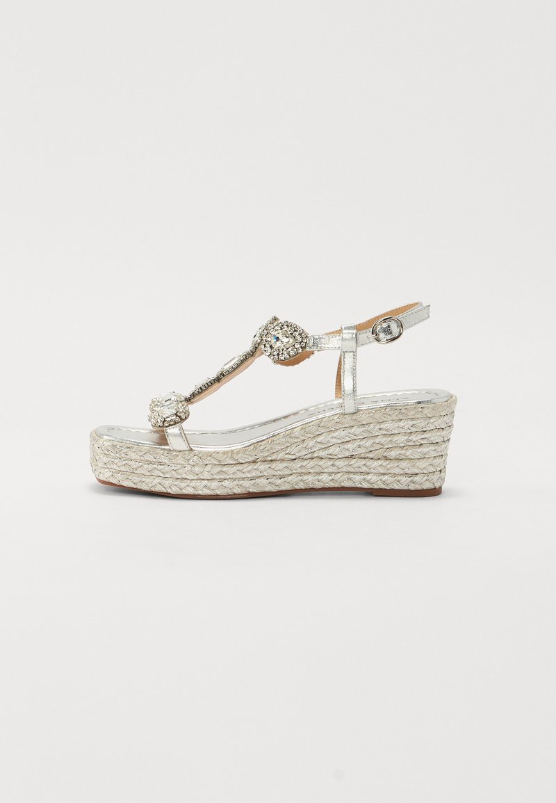 Sandalo wedge argentato con suola in corda intrecciata, abbellito con dettagli decorativi, dotato di una fascetta tra le dita e chiusura con cinturino alla caviglia.