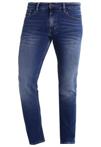 Vaqueros de mezclilla azul oscuro con un ligero despeje, cinco bolsillos, cremallera y perneras ligeramente ajustadas. Detalle de costura visible en toda la prenda.