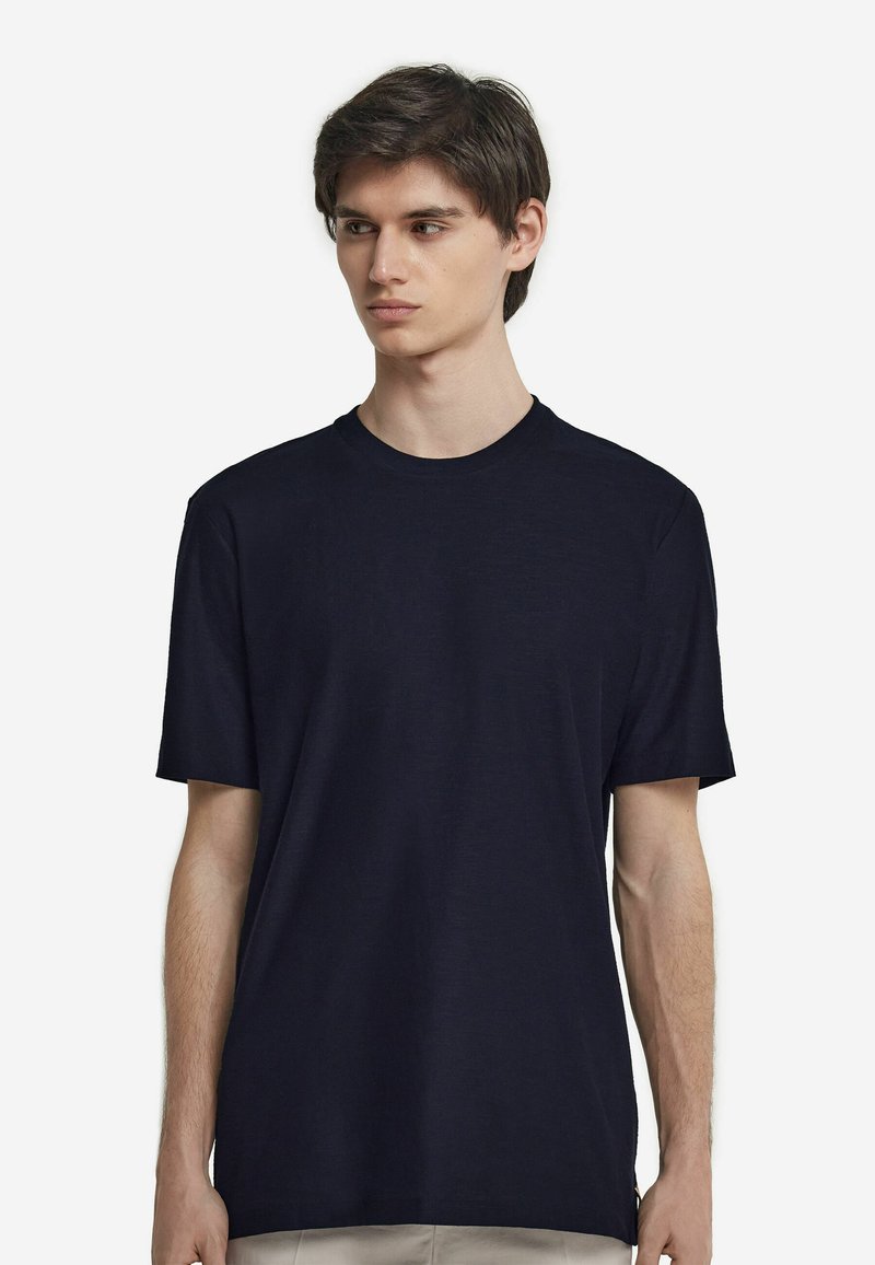 Mörkblå bomullströja med kort ärm, rund halsringning, avslappnad passform och slät yta. Minimalistisk design utan mönster eller detaljer.