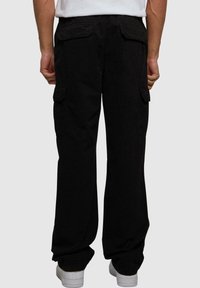Pantalon cargo noir à coupe décontractée, avec deux poches arrière, des poches latérales et un tissu en coton lisse.