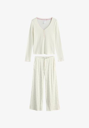 Bluză crem cu mâneci lungi, structură cu dungi fine, decolteu în V și pantaloni crem largi asortați, cu imprimeu floral subtil mic și talie cu șnur.