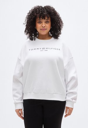 Fehér pulóver kerek nyakkivágással, hosszú ujjakkal és bordázott mandzsettákkal, tengerészkék logóval és "TOMMY HILFIGER EST. 1985." felirattal.