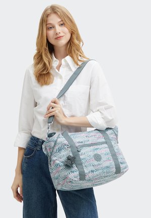 Colored duffel bag with a palm leaf pattern, light blue fabric, gray straps, and a zip pocket. Includes a small decorative charm.