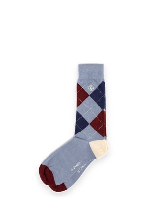 Calcetín azul único con patrón romboidal rojo y azul marino, talón crema, punta roja y nombre de la marca "El Ganso" impreso en la suela.