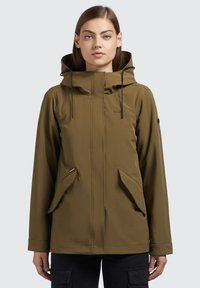 Giacca impermeabile verde con colletto alto e cappuccio, dotata di doppie tasche frontali e chiusura con zip, realizzata in materiale liscio e leggero.