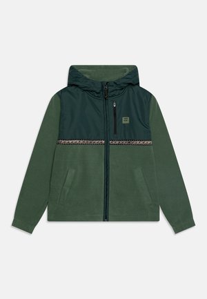 Zielona polarowa kurtka z kapturem, z ciemnozielonym panelem na klatce piersiowej, zamkiem z przodu, wzorzystą poziomą listwą i dwoma bocznymi kieszeniami.