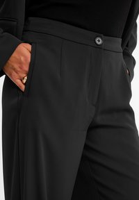 Svarta skräddarsydda byxor med en slät yta, sidofickor och knappstängning i midjan, i en slim fit rak design.