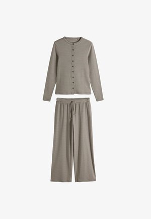 Knoopblouse met lange mouwen en brede broekspijpen met dunne zwart-witte horizontale strepen, elastische tailleband met trekkoord aan de broek.