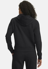 Felpa nera con cappuccio dal taglio comodo, polsini e orlo a costine e tessuto morbido. Dotata di cappuccio con coulisse e tasca a marsupio.