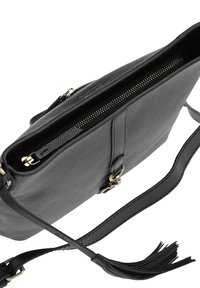 Sac bandoulière en cuir noir avec fermeture éclair dorée, fermeture à boucle et longue sangle se terminant par un détail en pampille, vu d'un angle supérieur.