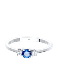 Silverring med en blå ädelsten i mitten, omgiven av två klara stenar, polerad yta, stilren design, präglad med "925" på insidan.