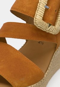 Καφέ σουέντ πλατφόρμα σάνδαλο με διασταυρούμενους ιμάντες, λεπτομέρειες πλεξίματος από σχοινί γύρω από την αγκράφα και υφασμένο πάτο με υφή. Μέγεθος 4,5.