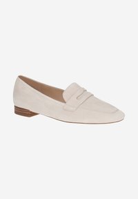 Beige suede loafers with a flat wooden heel, featuring a stitched strap over the vamp and a pointed toe. Smooth texture and minimalist design.