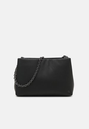 Sac à épaule rectangulaire noir avec une bandoulière chaîne argentée et un petit logo 'cK' en bas à droite.
