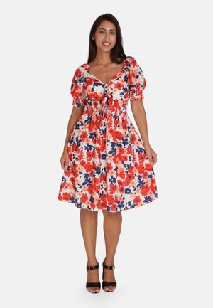 Vestido floral en rojo, azul marino y crema con mangas abullonadas, un cuerpo ajustado y falda acampanada; tejido texturizado con detalle de cintura ajustable.