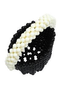 Cestino di perline bianco e nero; forma circolare con una superficie texturizzata; perline bianche decorative creano un design per il manico.