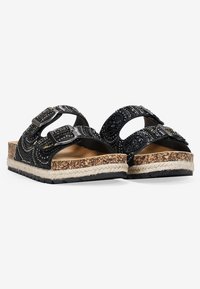 Sandales noires à glissière avec une tige en tissu texturé, deux boucles réglables, et une semelle en liège avec une finition en jute, arborant un design à motif.