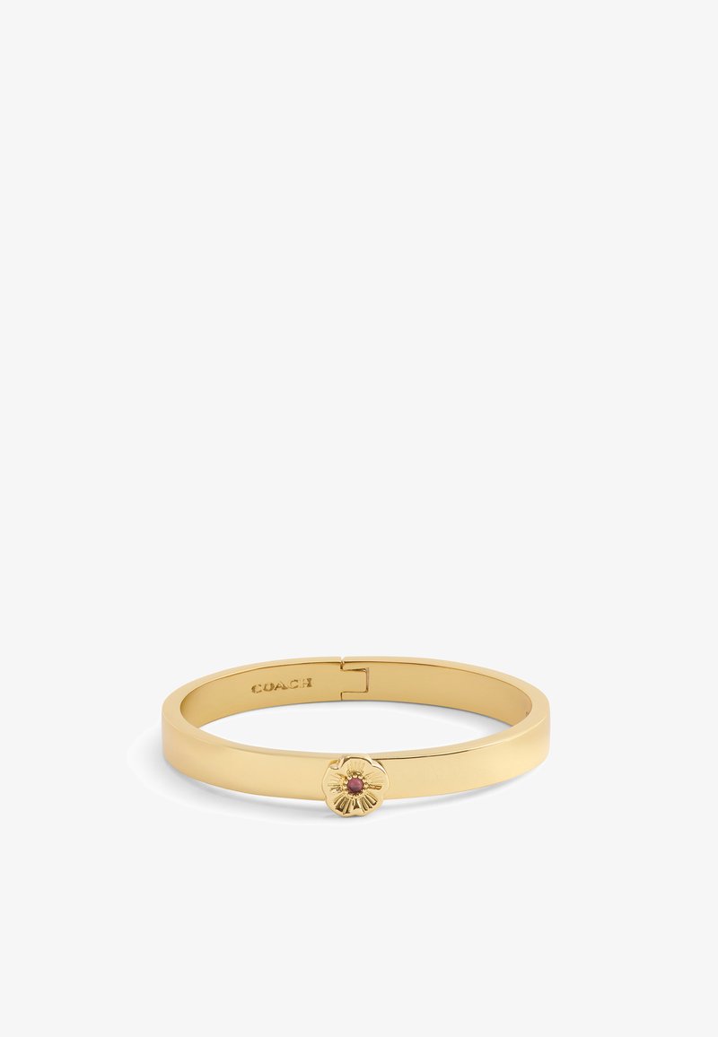 Gouden metalen bangle armband met een bloemaccent en een centrale roze steen. Gladde oppervlakte, slank ontwerp en een veilig sluitmechanisme.