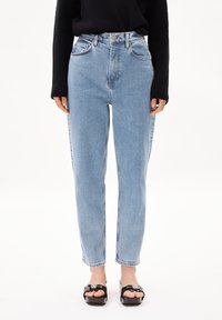 Jean en denim bleu clair à taille haute, design à jambe droite, avec un léger délavage, cinq poches et un bouton devant.