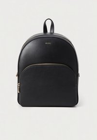 Zwarte leren rugzak met afgeronde bovenkant, voorvak met ritssluiting, gouden metalen accenten en een bovenste draaghandvat. Minimalistisch ontwerp.