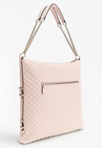 Jasnoróżowa pikowana torebka na ramię ze złotym łańcuszkiem i skórzanymi paskami, z przednią kieszenią na zamek oraz regulowanymi klamrami po bokach, prezentowana na białym tle.