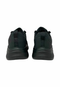 Czarne buty sportowe z teksturowaną gumową podeszwą, wyprofilowanym kołnierzem i pętelką z tyłu. Otwory wentylacyjne wzdłuż cholewki.