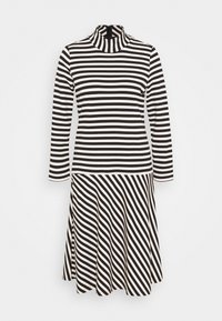 Svart och vit randig långärmad klänning med hög halsringning och utsvängd kjol, med diagonala ränder på den nedre halvan.