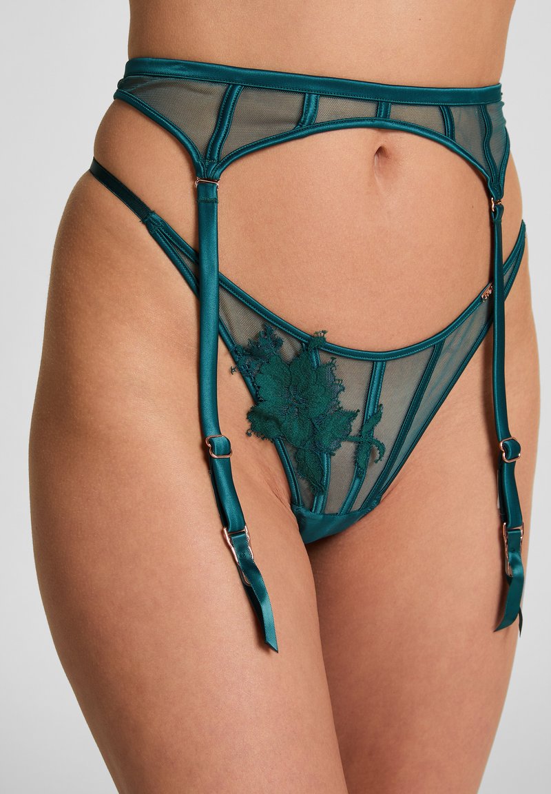 Teal mesh jarretel met decoratieve bloemenkant details, voorzien van verstelbare satijnen banden en metalen hardware accenten voor het vastmaken.