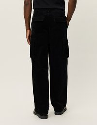 Schwarze Cord-Hosen im Cargo-Stil mit lockerer Passform, ausgestattet mit seitlichen Taschen, Gesäßtaschen und einem sichtbaren, strukturierten Stoff.