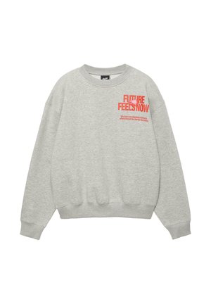 Jasnoszara bluza z okrągłym dekoltem, z czerwonym napisem "FUTURE FEELS NOW" oraz mniejszym sloganem na lewej piersi, z długimi rękawami, ściągaczami przy mankietach i u dołu.